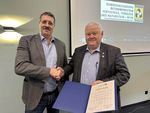 Andreas Teich vom BFTN, links, überreicht Harald Zahn die Goldene Ehrennadel für sein Engagement im Betonstein- und Terrazzoherstellerhandwerk. 